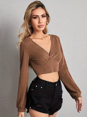 Textured wrap-front crop top in tan with long sleeves and a V-neck.