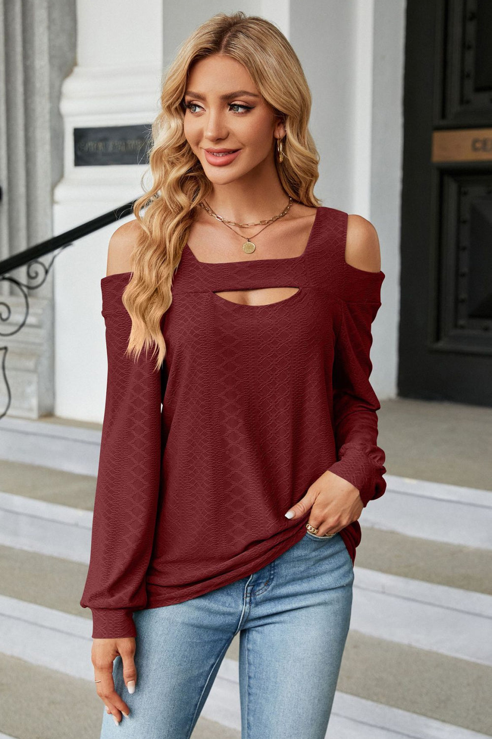 Burgundy textured open shoulder blouse with keyhole neckline and long sleeves.