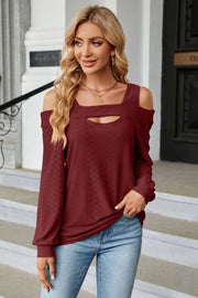Burgundy textured open shoulder blouse with keyhole neckline and long sleeves.