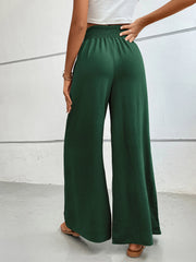 Textured palazzo lounge trousers in dark green with a smocked waistband.