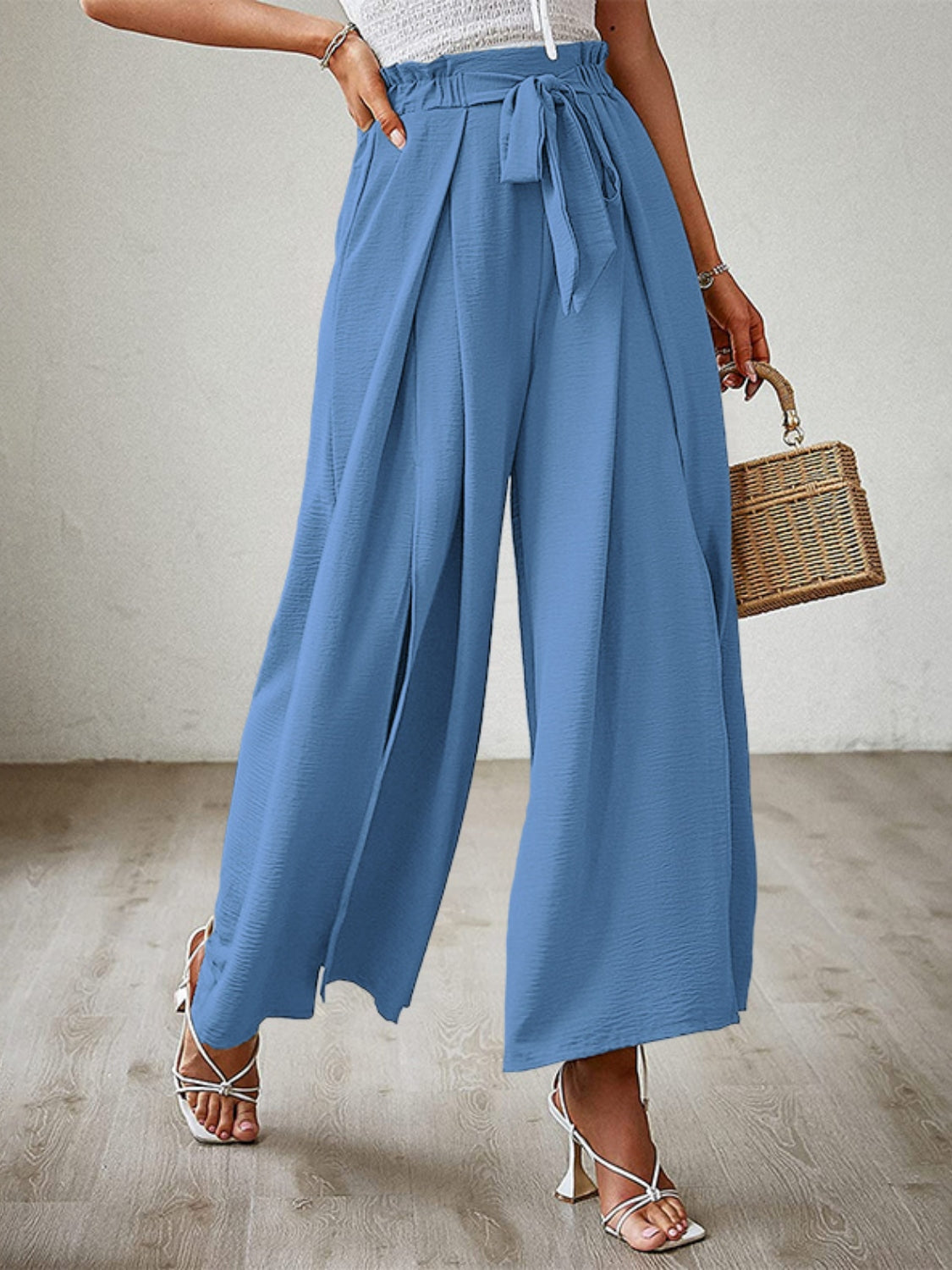 Blue paperbag waist palazzo pants with side slits and tie belt.