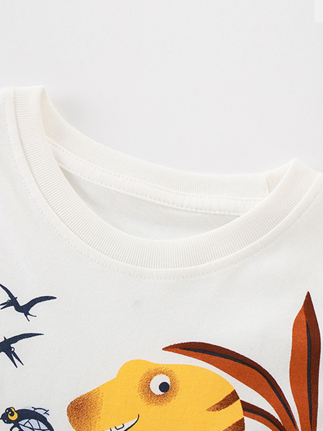 White cotton toddler t-shirt with a dinosaur and flying creatures graphic print