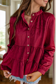 Burgundy corduroy tiered button-up blouse with band collar and ruffled tiers.