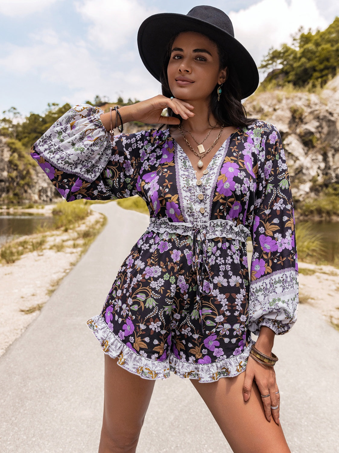 Floral print blouson sleeve romper with tie waist and ruffled hem.