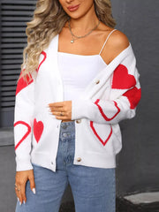 White acrylic button up cardigan with red heart pattern, long sleeves.