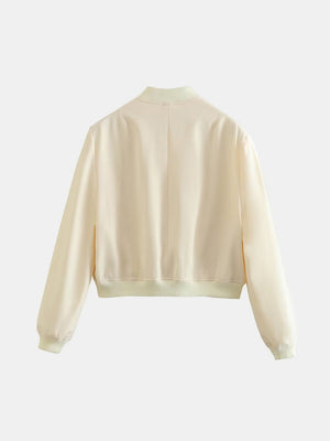 Cream utility bomber jacket with ribbed collar, cuffs, and hem.