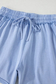 Light blue acid-washed cotton drawstring shorts with pockets and elastic waistband.
