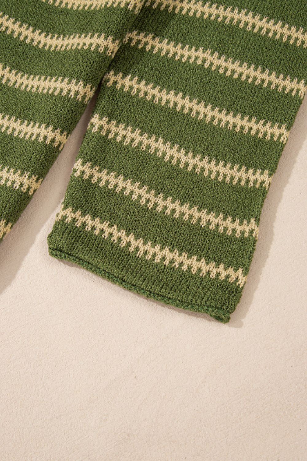 Moss green knit sweater with textured cream stripes and a relaxed fit.