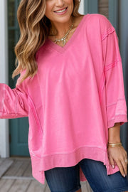 Pink V-neck tee with raw-edge seam details and relaxed fit.