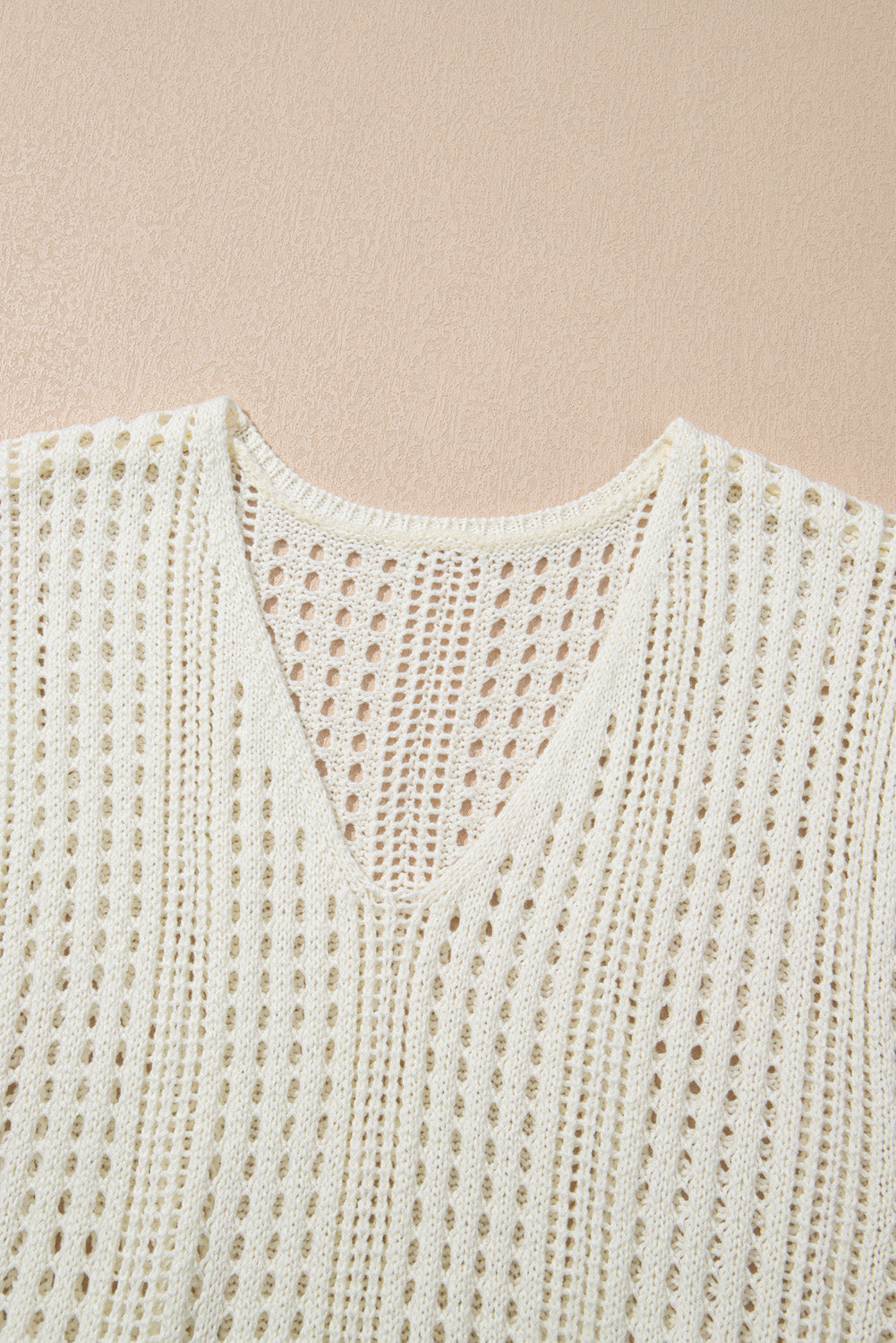 Beige open-knit mini dress with V-neck and drawstring waist detail.