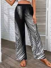Black and white palm print palazzo trousers with a wide leg cut.