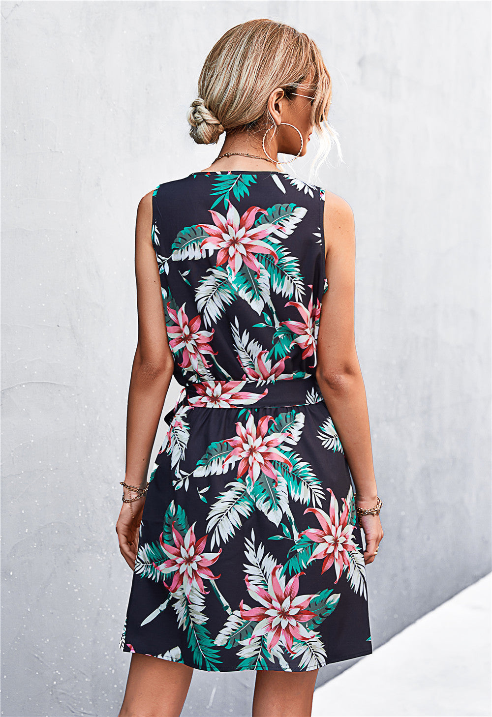 Black floral mini dress with tie waist and zip front, sleeveless.
