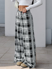 Black plaid wide-leg track pants with white drawstring and gray side stripe.