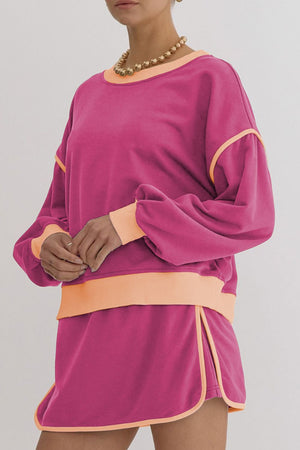 Pink sweatshirt and skort set with contrast trim and balloon sleeves.
