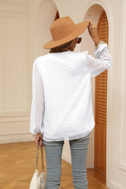 White Swiss dot blouse with poet sleeves and ruffled cuffs, shown from the back.