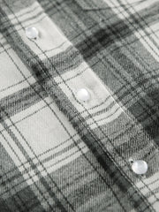 Button-up long sleeve shirt in black and white plaid cotton with pearl buttons.