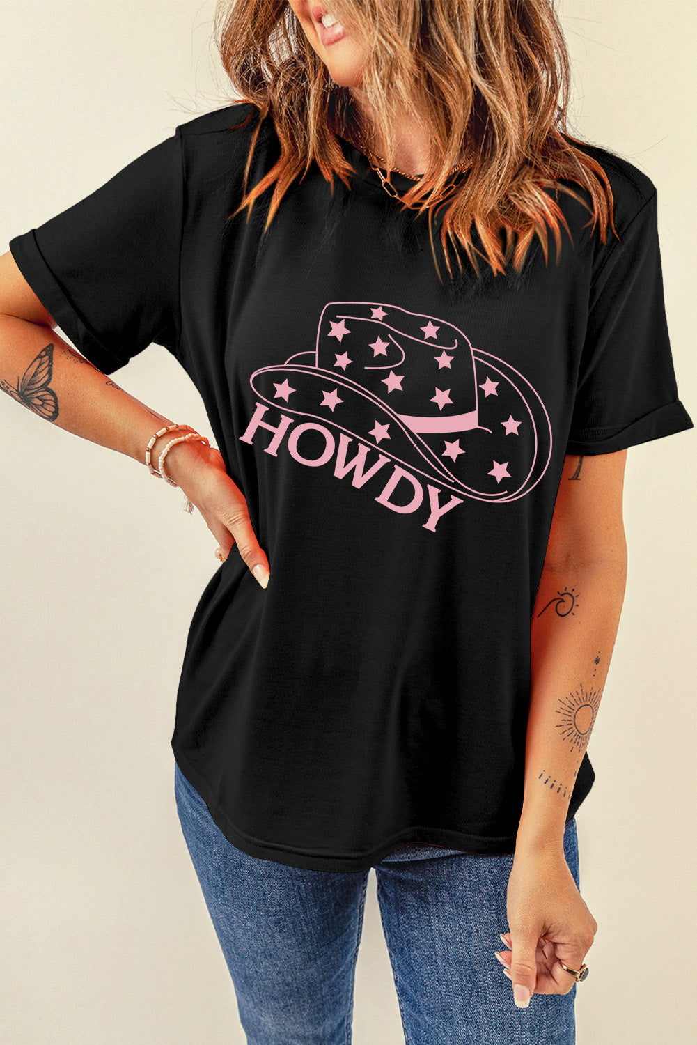 Black cotton t-shirt with rolled sleeves and a pink Howdy cowboy hat graphic with stars.