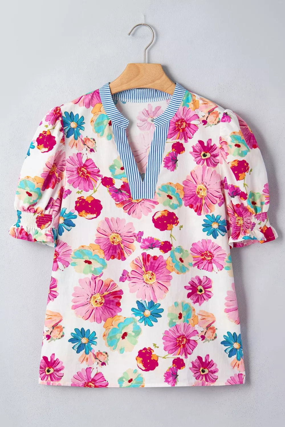 Vibrant floral print cotton blouse with V-neck and striped trim, short puff sleeves with smocked cuffs.
