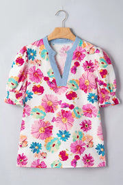 Vibrant floral print cotton blouse with V-neck and striped trim, short puff sleeves with smocked cuffs.