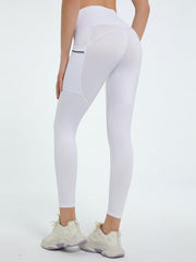 White pocketed sculpt leggings with mesh paneling and a zippered pocket detail.