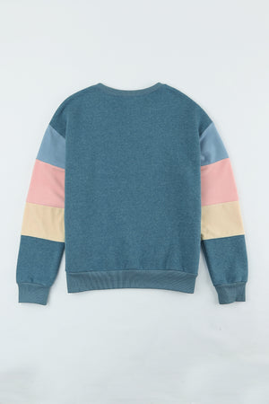 Crewneck sweatshirt with colorblock sleeves in French blue, dusty pink, and cream.