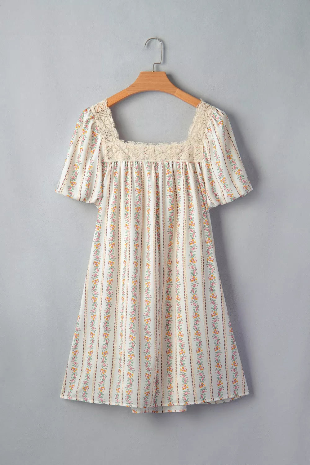 Floral mini dress with lace trim, square neck, short puff sleeves, and vertical floral stripe pattern.