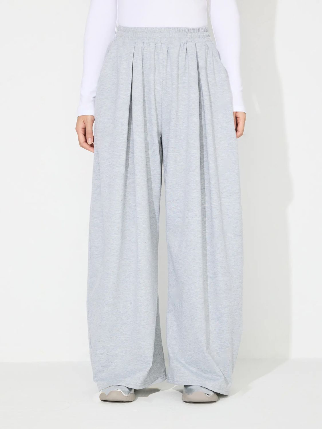 Light gray pleated drape palazzo trousers with elastic waistband.