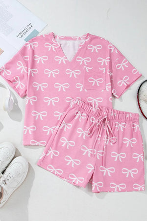 Pink ribbed loungewear set with white bow print, V-neck top with pocket, and drawstring shorts.