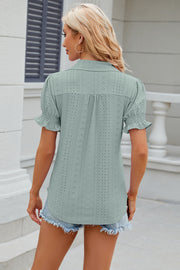 Light green eyelet polo blouse with short ruffled sleeves and button detail.