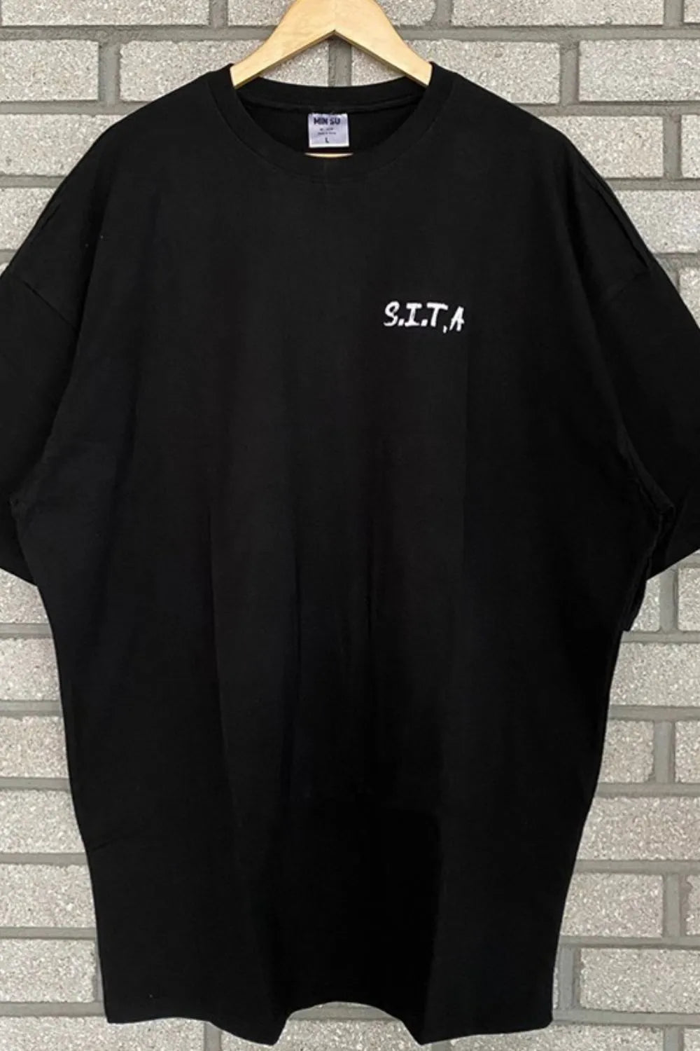 Black oversized t-shirt with white S.I.T.A. text graphic on chest