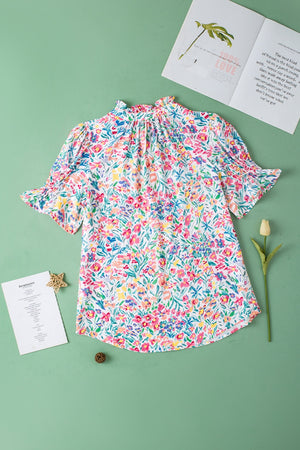 Floral ruffle collar puff sleeve blouse with smocked cuffs and a bright floral print.
