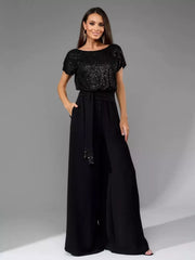 Black sequin wide-leg jumpsuit with tie waist and short sleeves.