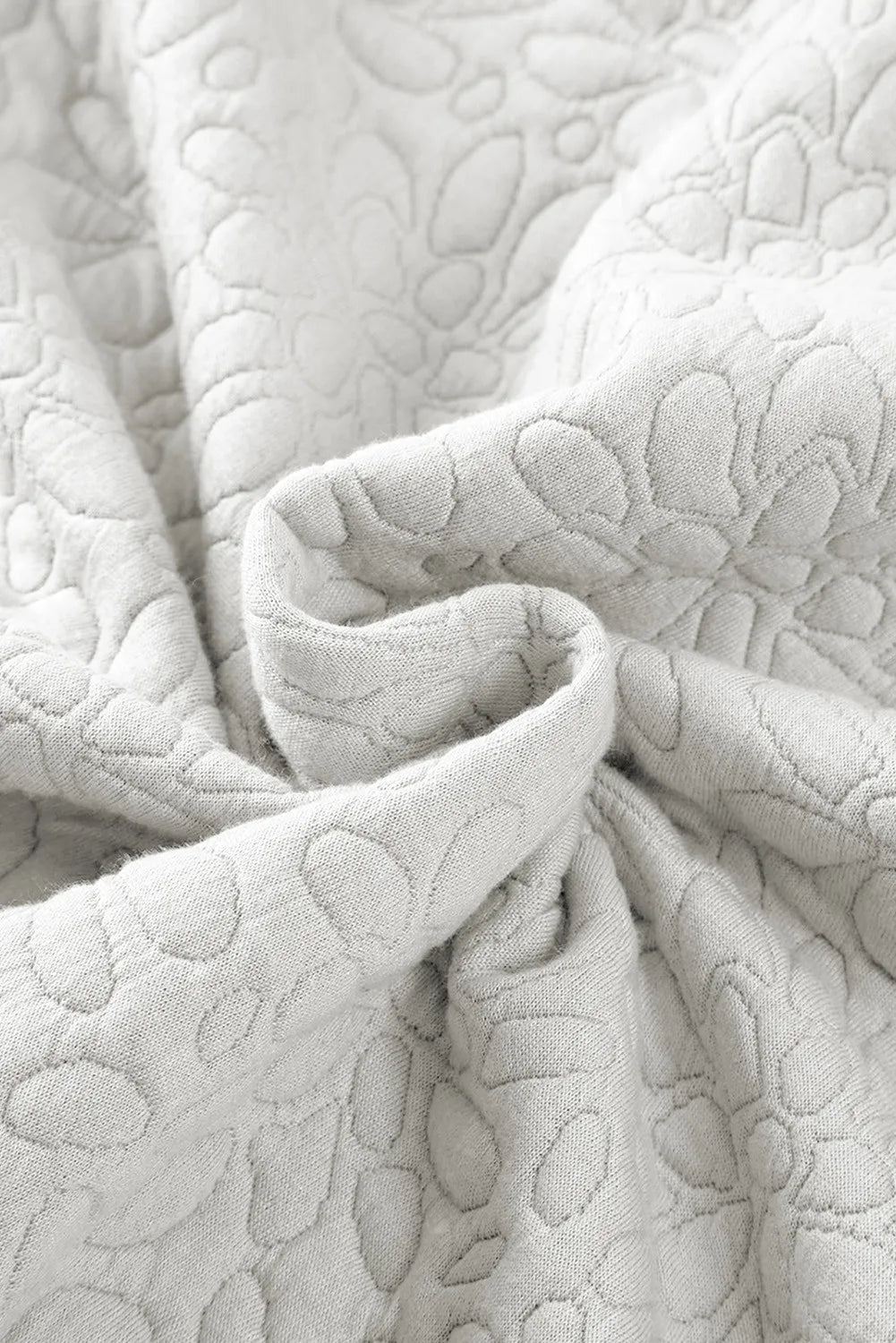 White bomber jacket with subtle embossed floral pattern
