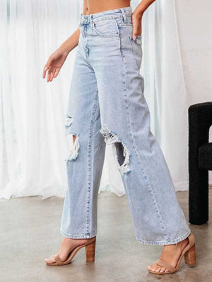 Light wash distressed wide leg denim flare jeans with ripped details.