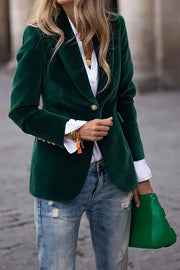 Green velvet blazer with gold button detail, lapel collar, and cuffed sleeves.