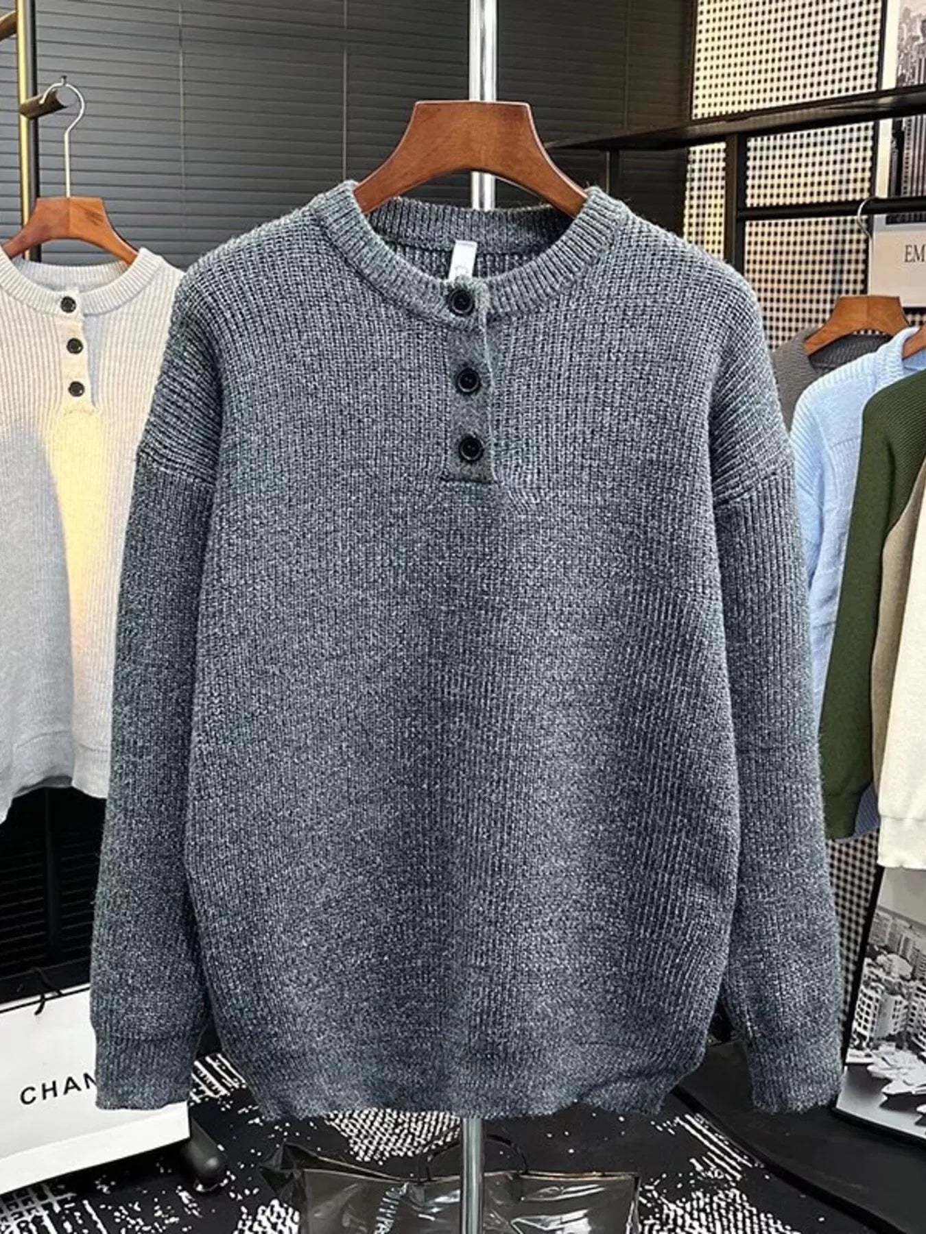 Plus-size gray knit sweater with button detail and crew neck.