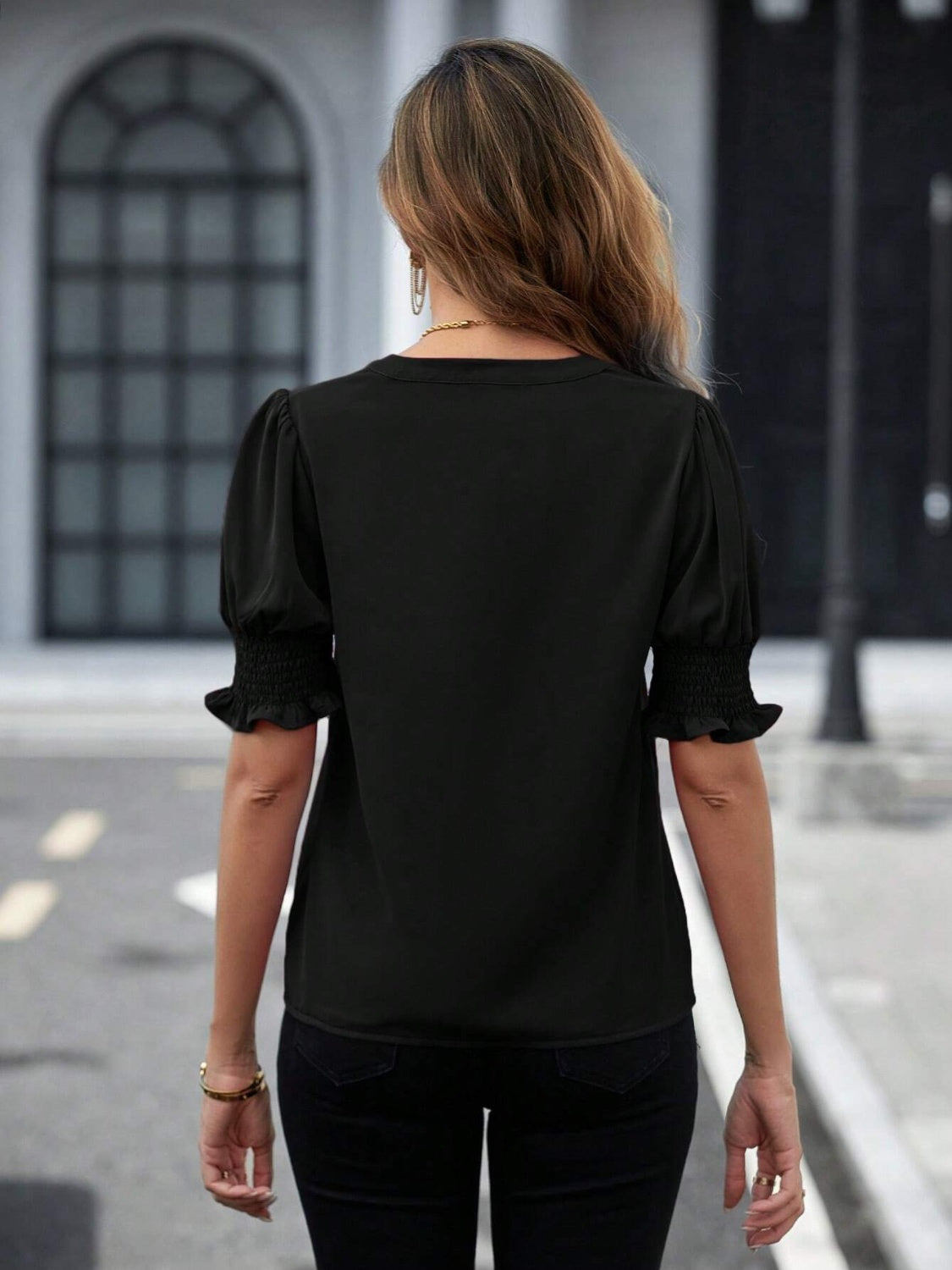 Black shirred sleeve blouse with ruffle cuffs and a V-neckline.