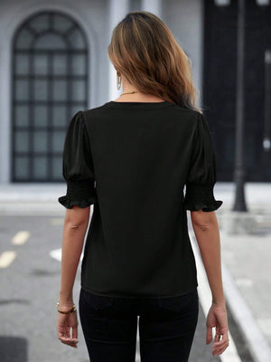 Black shirred sleeve blouse with ruffle cuffs and a V-neckline.