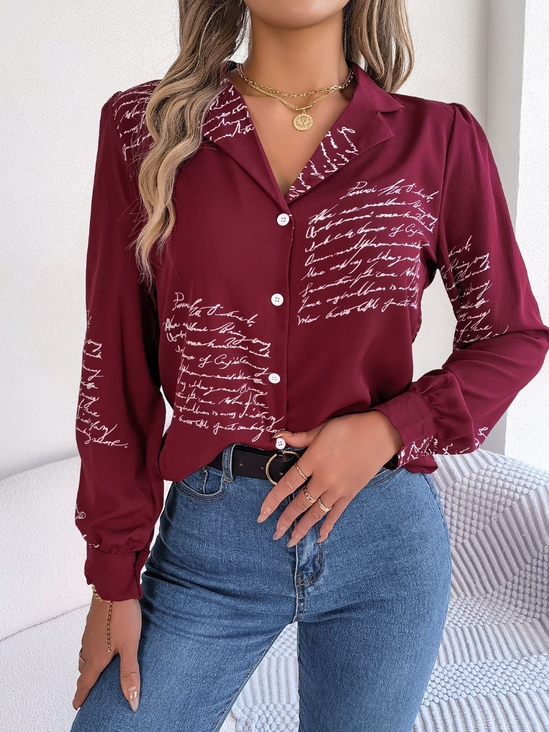 Burgundy collared blouse with white script print, button front, and long sleeves.