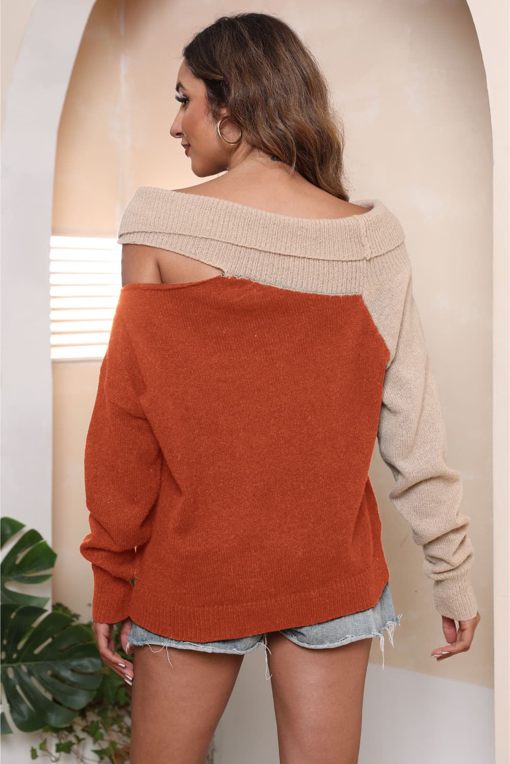 Asymmetric shoulder block sweater in rust and beige acrylic with boat neck.