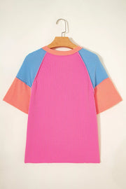 Vibrant ribbed V-neck t-shirt with color block sleeves in pink, blue, and orange.