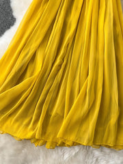 Yellow pleated chiffon halter dress with a flowing skirt detail.