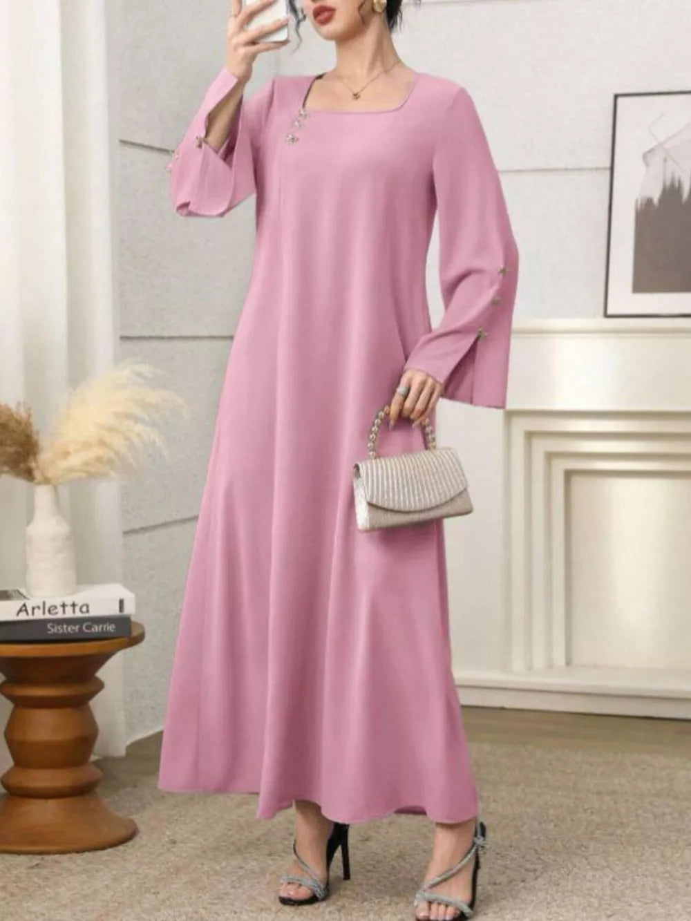 Pink maxi dress with square neckline, bell sleeves with button detail, and a flowy skirt.