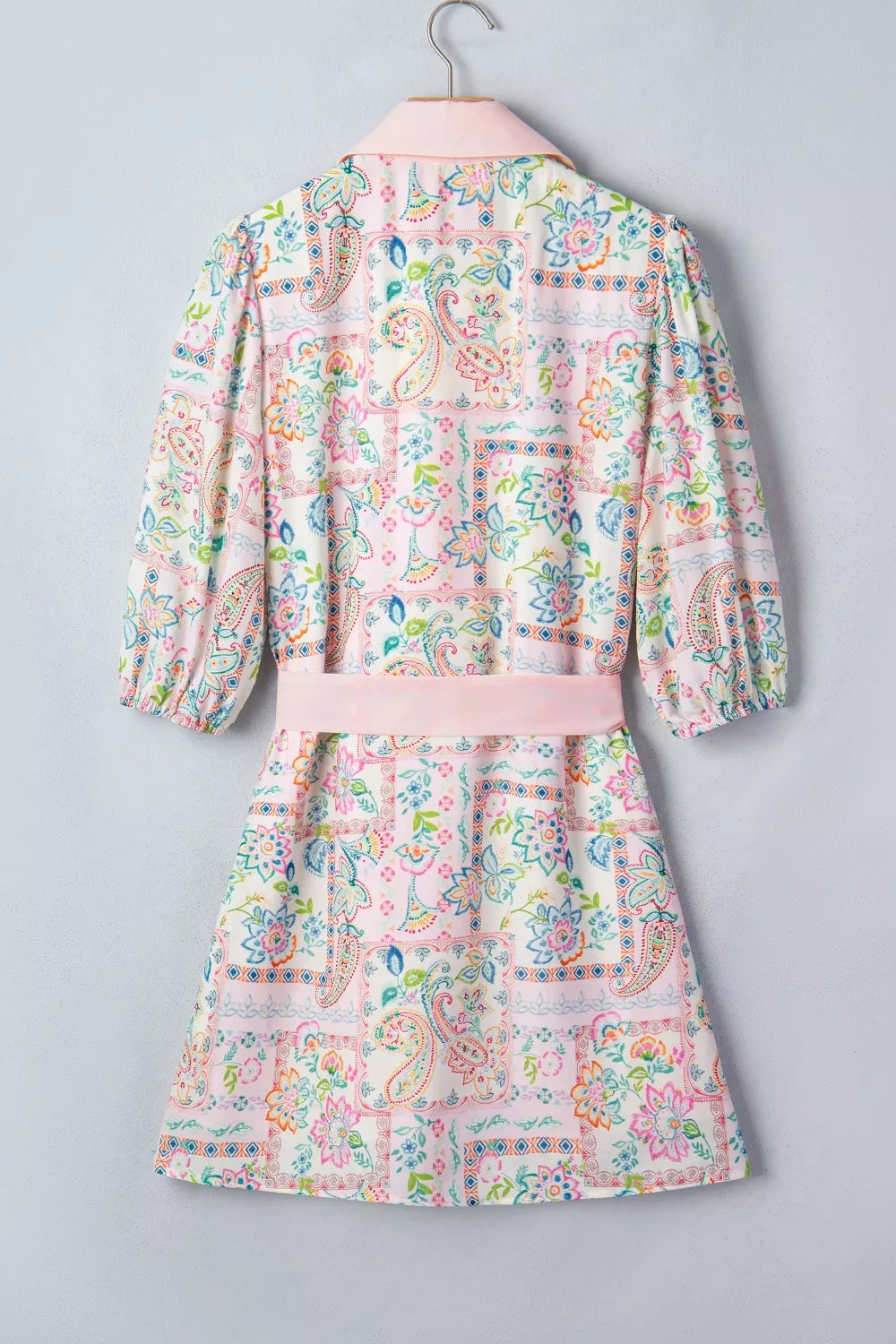 Floral patchwork mini dress with 3/4 sleeves, pink belt, and button-down front.