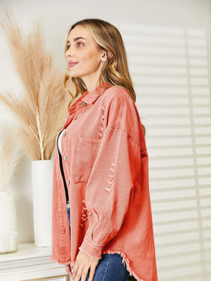 Distressed denim overshirt in orange-red with raw hem and buttoned front.