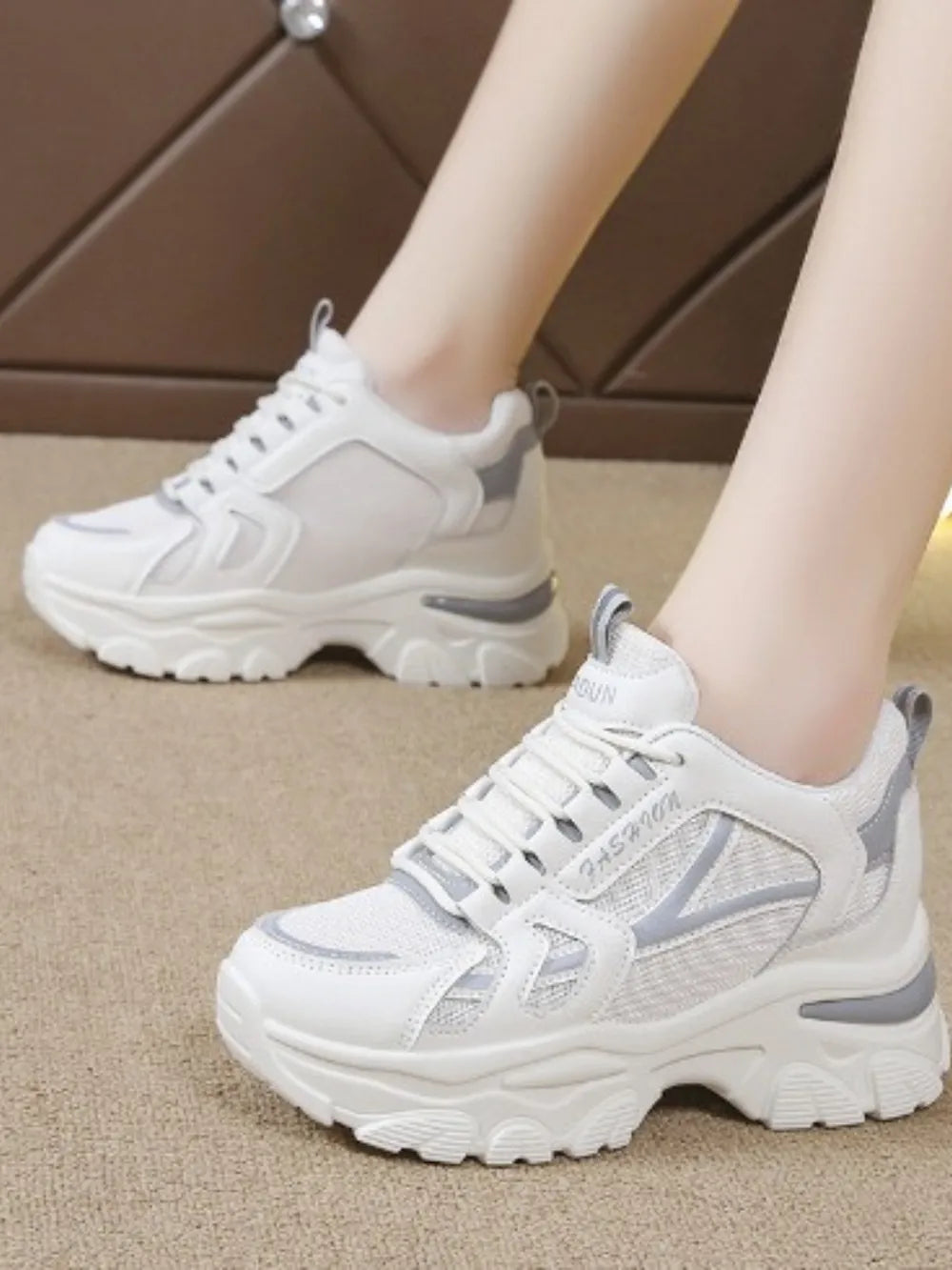 White mesh and leather chunky sneakers with gray accents and a thick sole.