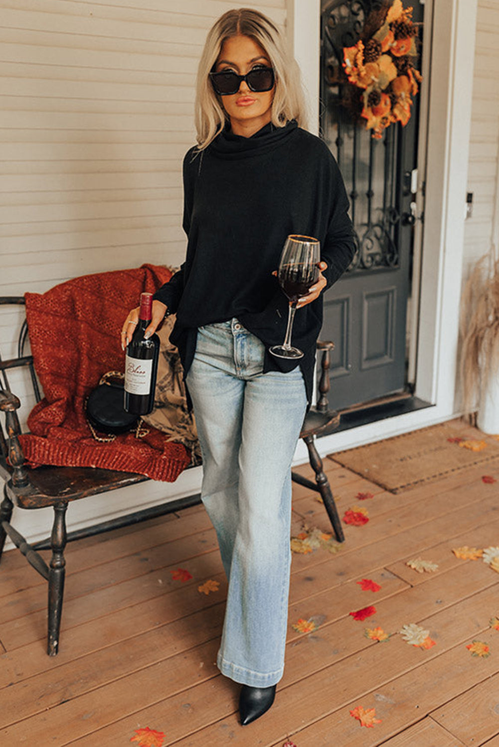 Black drape-front cowl neck tunic with long sleeves, styled with light wash jeans.