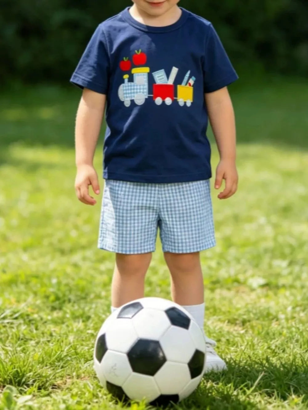 Navy embroidered tee with train and apples, paired with blue gingham shorts.