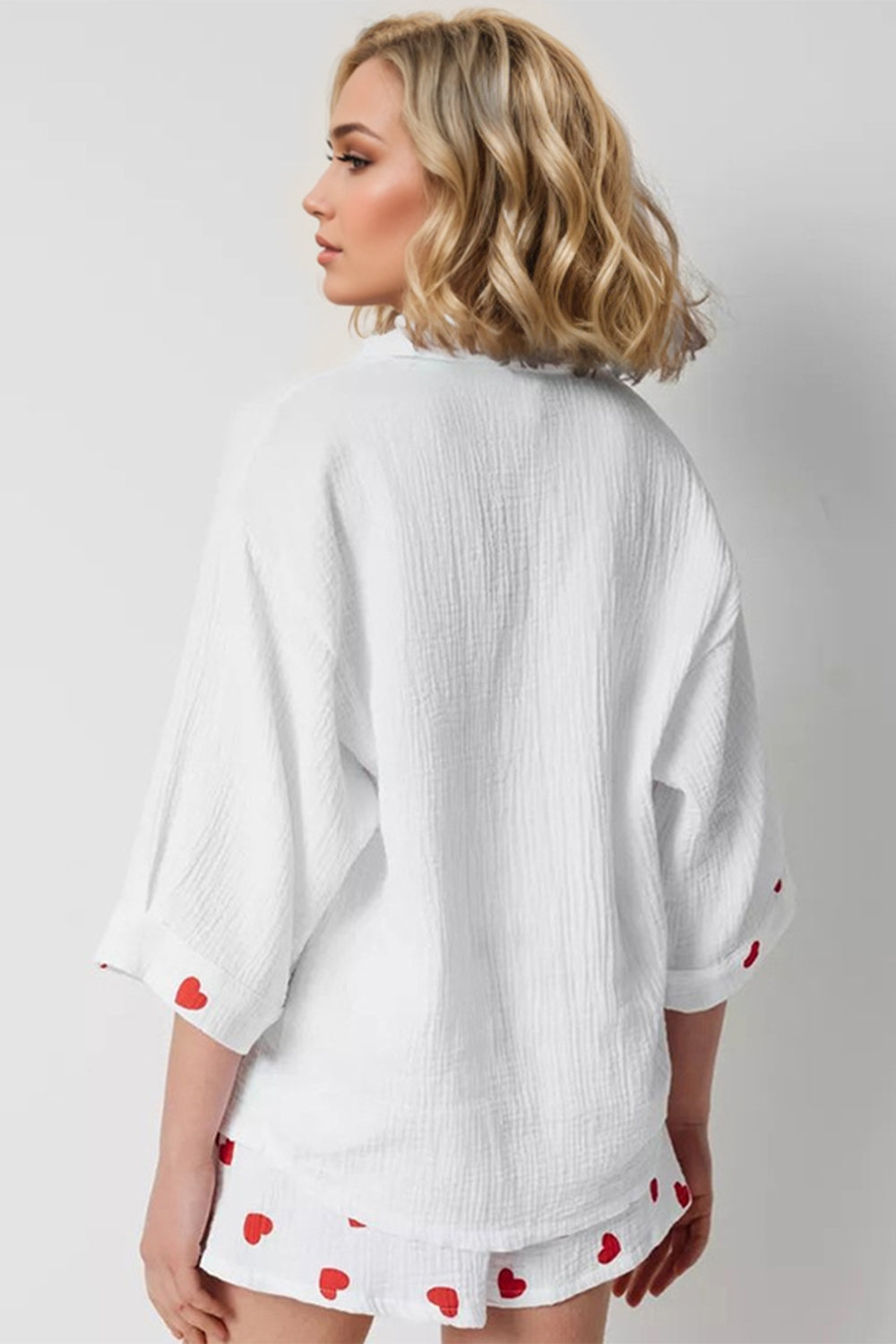 White gauze pajama set with red heart print on cuffs and shorts.