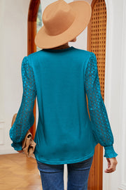 Turquoise knit top with lace sleeves and smocked cuffs.